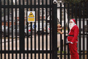 Photo of Santa standing in front of the perimeter fence of the Pease Pottage center